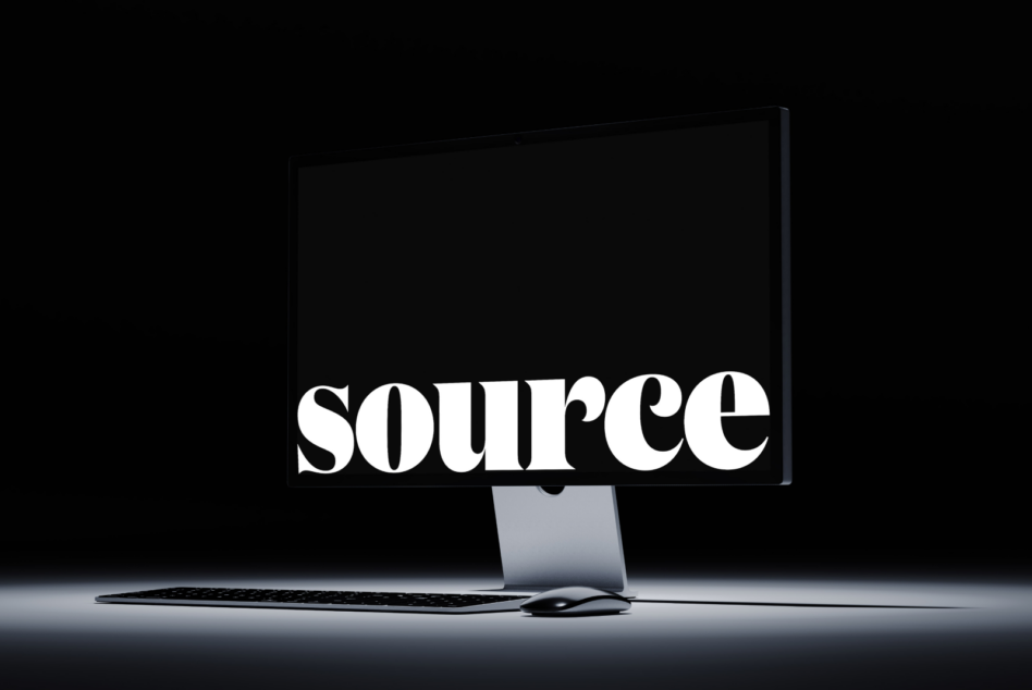 Monitor displaying SOURCE in bold serif font with wireless peripherals