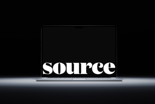 Large serif font spelling SOURCE glowing on dark laptop display