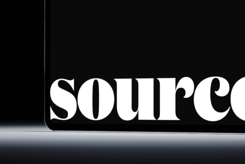 Tablet edge close-up showing 'source' text in white serif typeface