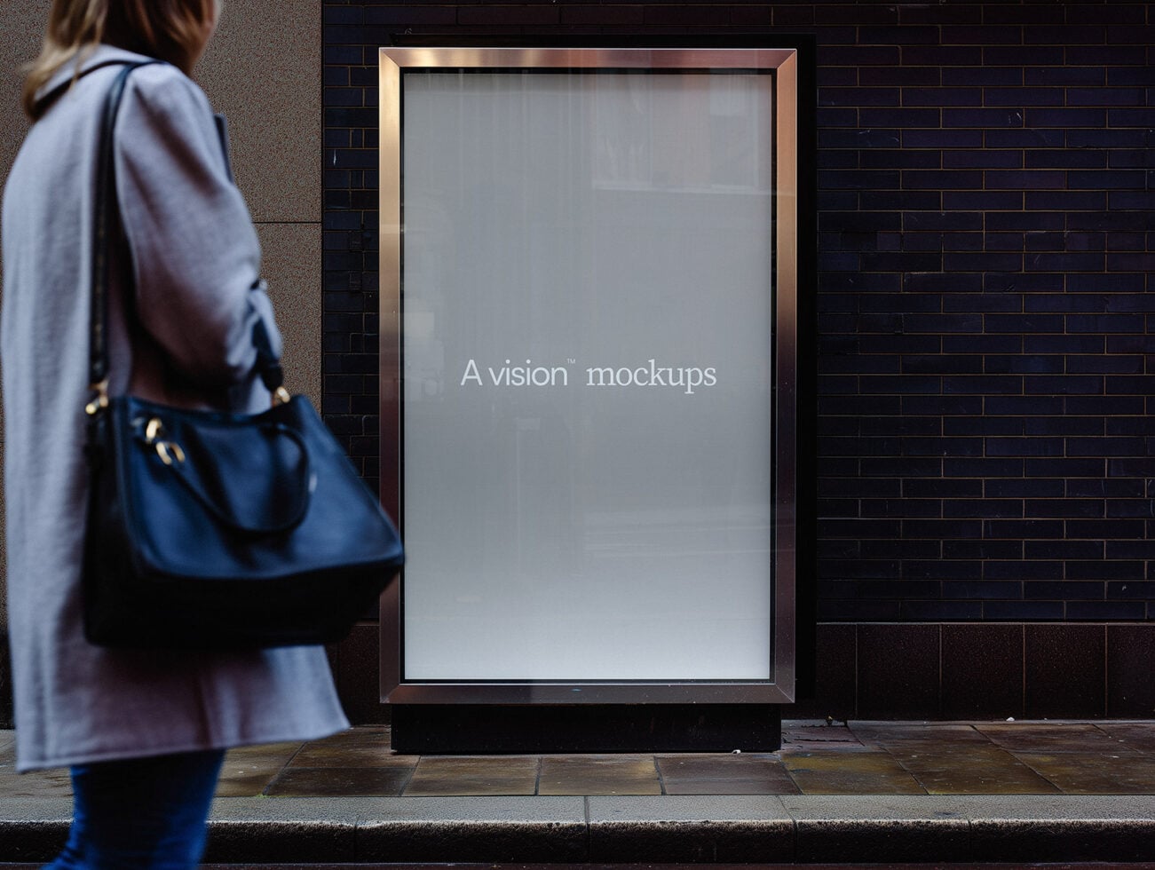 Street display case with blank screen, gold frame on brick wall
