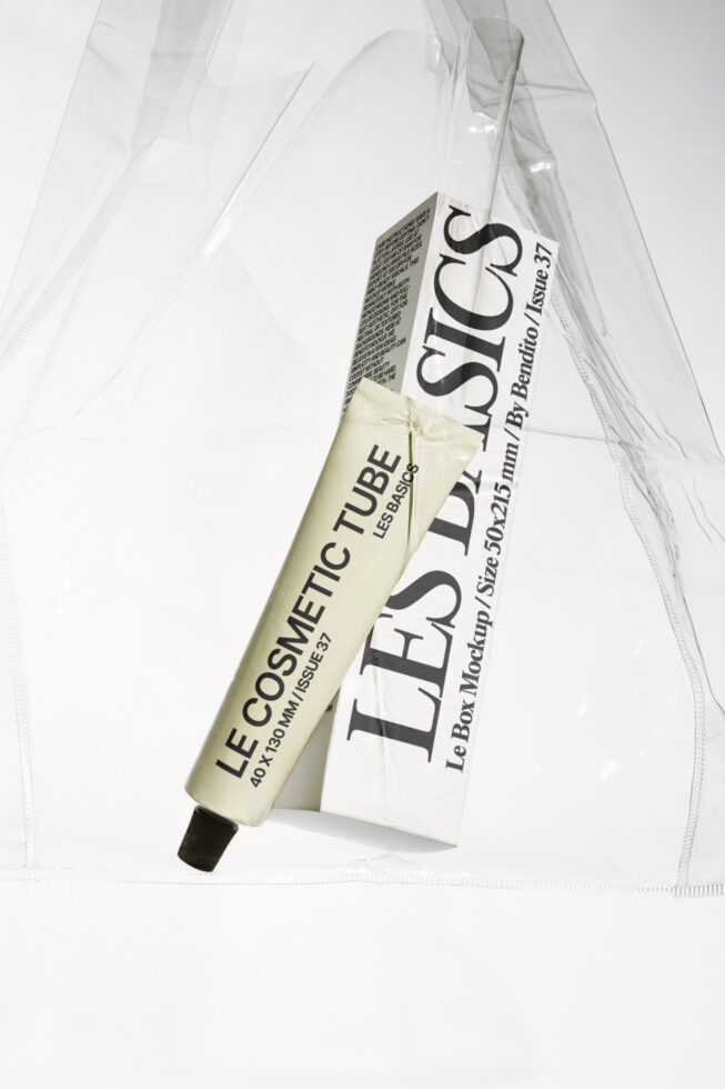 Cream cosmetic tube with black text next to white box mockup on draped fabric