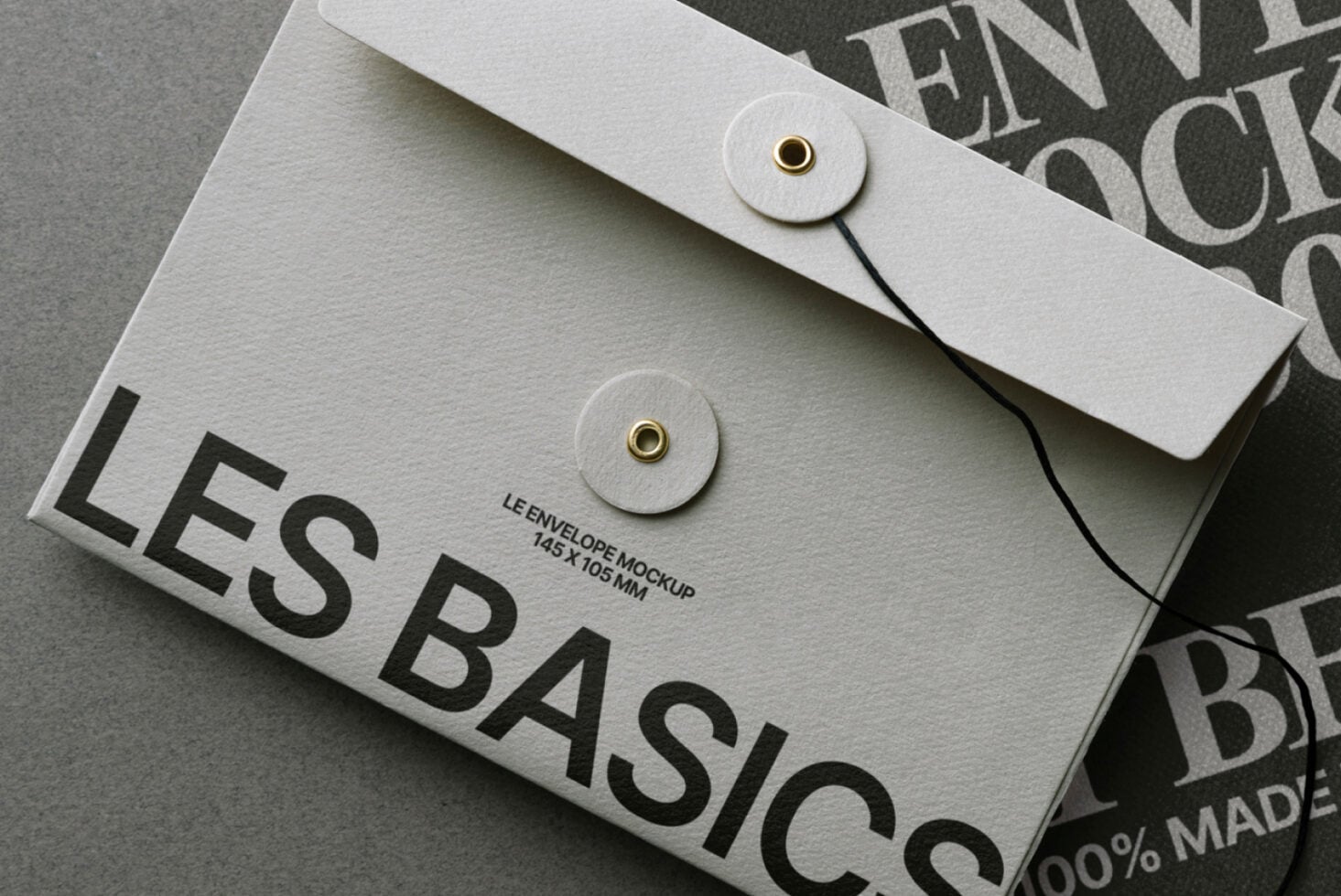 Cream envelope with brass closure on stacked branded documents showing design system application
