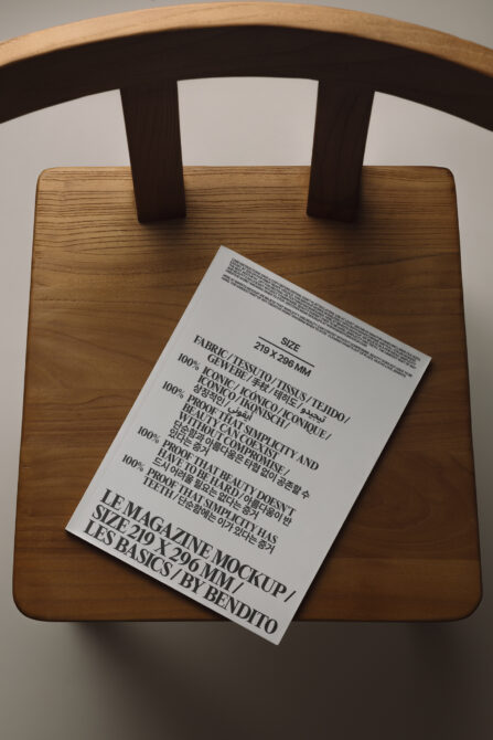 White magazine mockup laying on wooden chair seat with care label visible