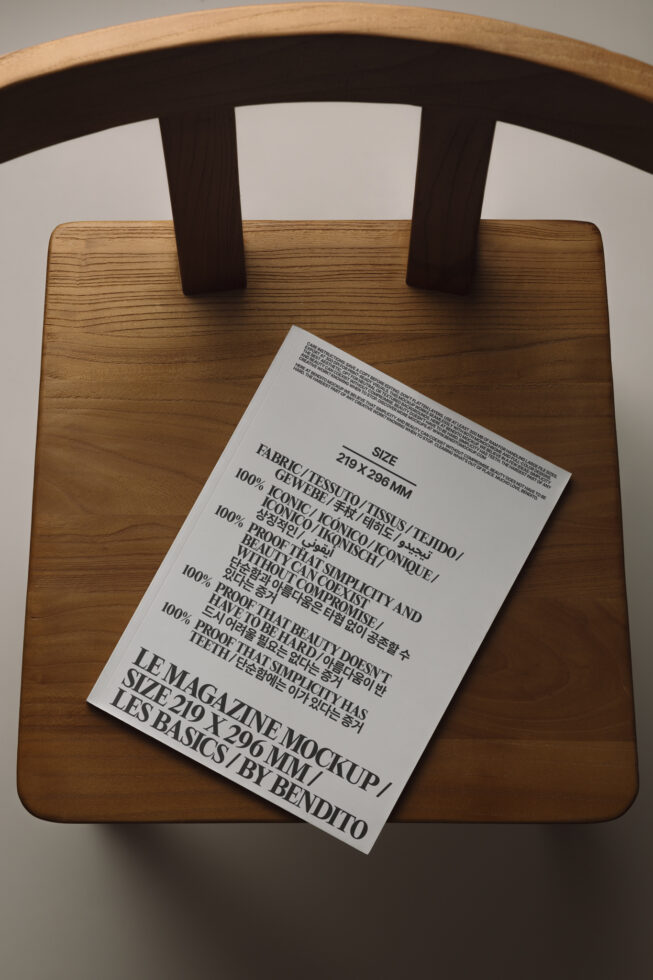 White magazine mockup laying on wooden chair seat with care label visible