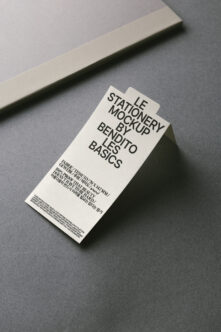 Overhead shot of cream tag mockup on gray surface with beige stripe backdrop
