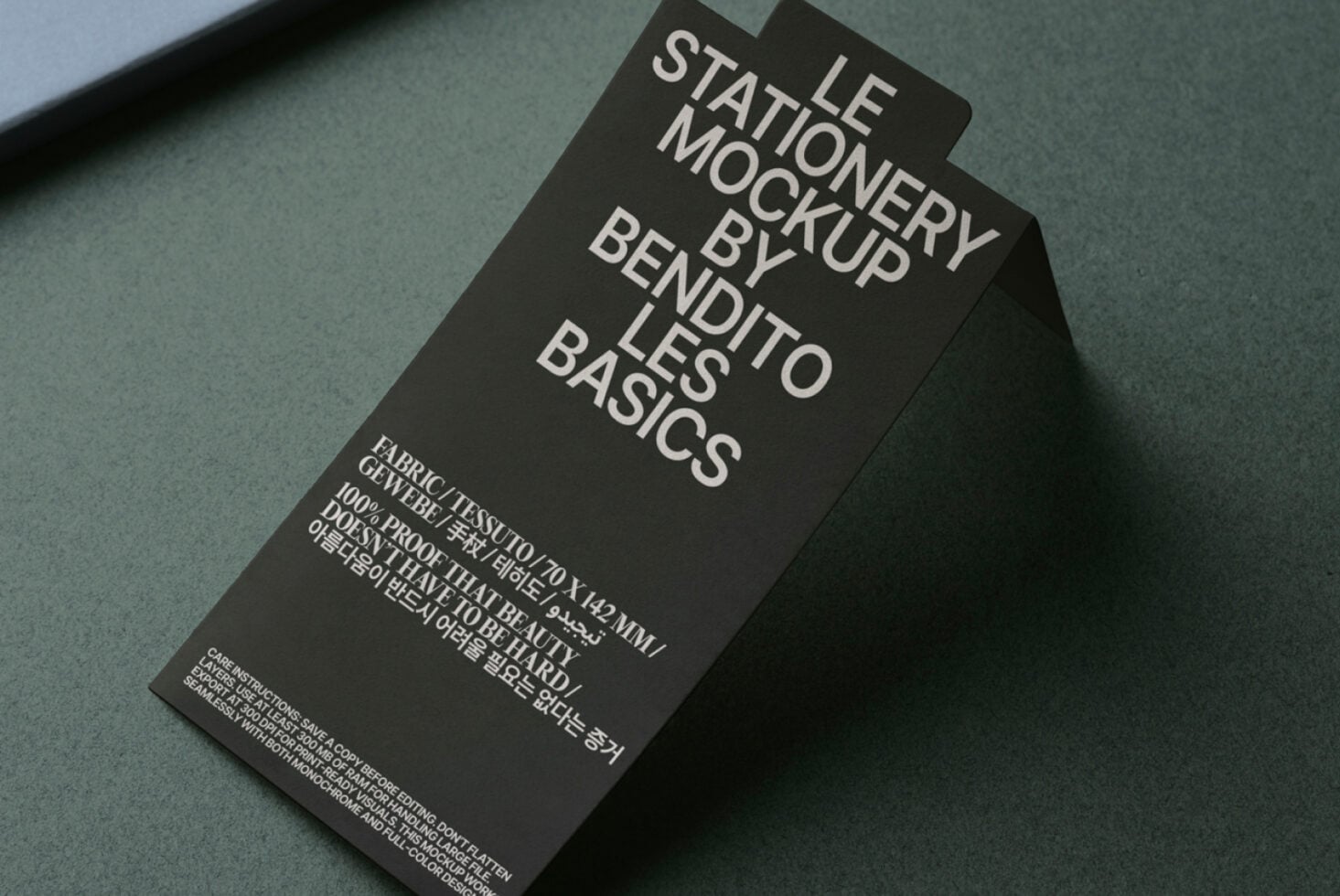 Overhead shot of dark tag mockup on green surface showing typography layout