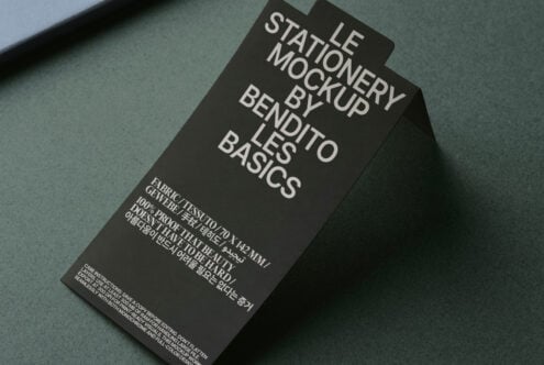 Overhead shot of dark tag mockup on green surface showing typography layout