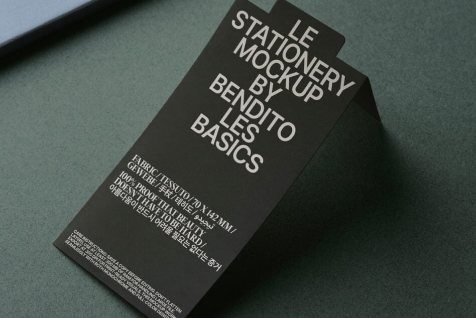 Overhead shot of dark tag mockup on green surface showing typography layout