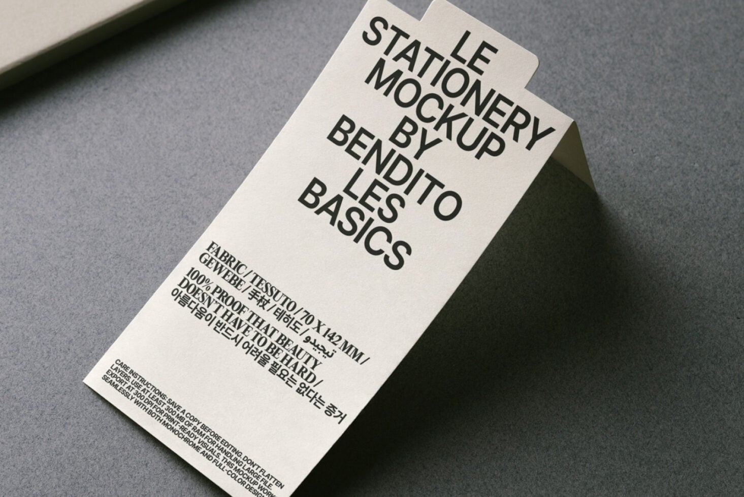 Overhead shot of cream tag mockup on gray surface with textured backdrop