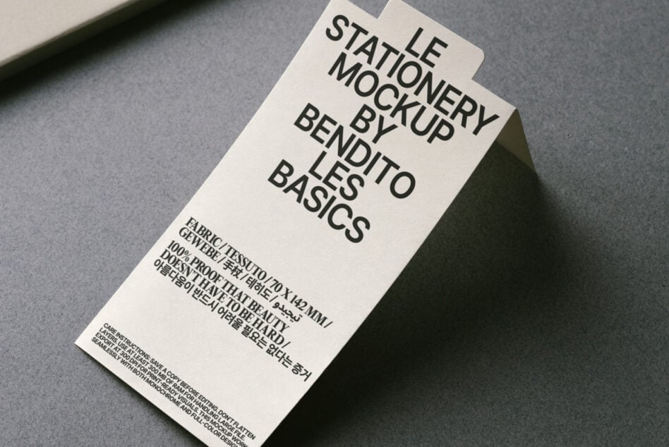 Overhead shot of cream tag mockup on gray surface with textured backdrop