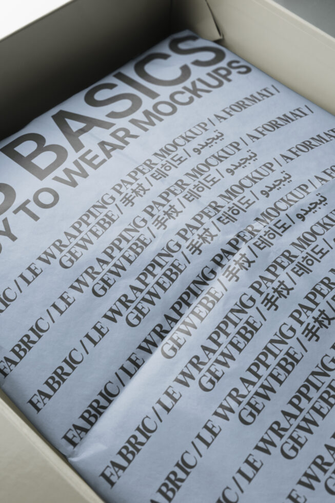 Open white box showing blue paper mockup with large black text layout inside
