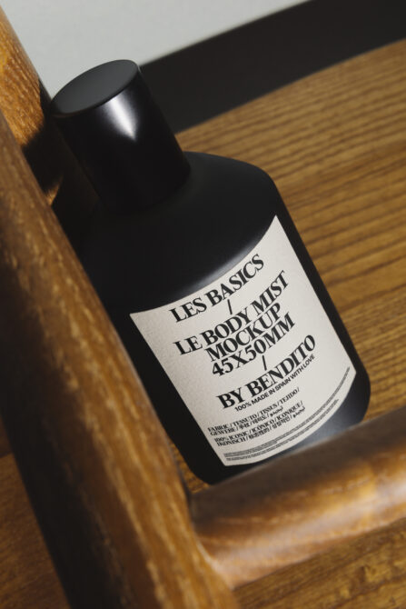 Black mist bottle with cream label on wooden surface showing product details