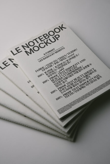 Fanned white notepads with stitched edge showing typography mockup design