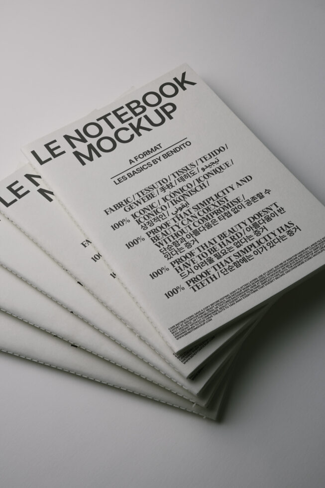 Fanned white notepads with stitched edge showing typography mockup design