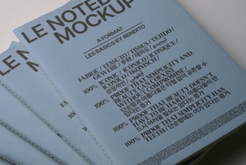 Stacked blue bound notebooks showing multilingual text mockup on cover