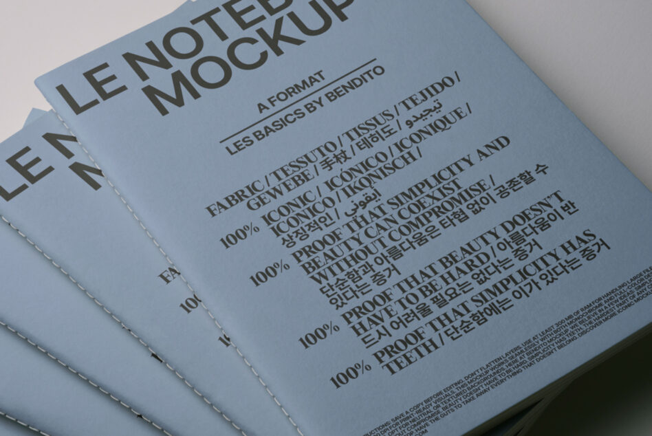 Stacked blue bound notebooks showing multilingual text mockup on cover