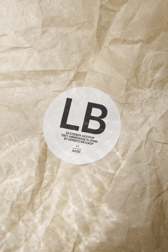 Round white sticker with large LB letters on crinkled kraft paper background