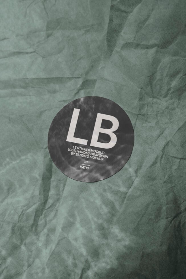 Circular black sticker mockup on crumpled kraft paper texture
