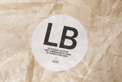 White circular sticker printed with LB lettering on beige wrinkled paper surface