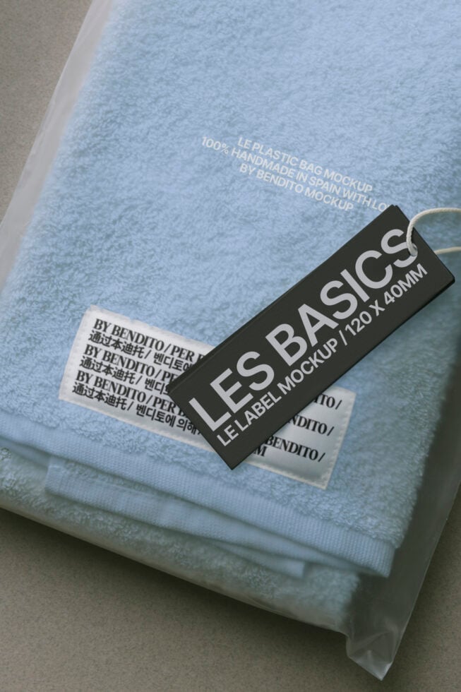 Folded light blue fabric with black woven label showing size details