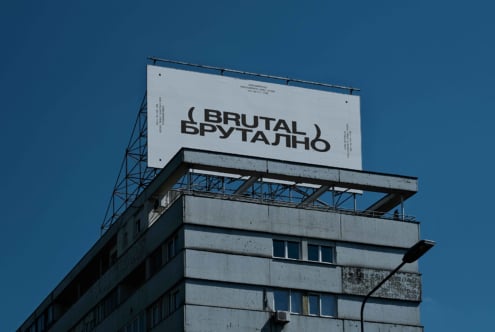 Light grey billboard on concrete tower displaying Brutal branding in bold sans serif
