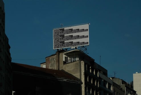 Billboard with repeating text layout mockup positioned on concrete structure in daylight