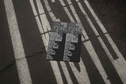 Black poster mockup photographed on ground with building shadow patterns