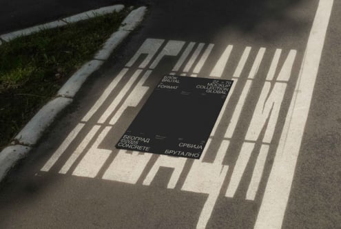 Black poster mockup on sunlit concrete with bold sans serif typography