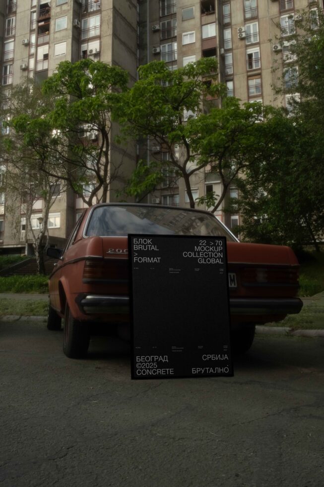 Large poster mockup mounted on vintage car in urban courtyard with Soviet-era buildings