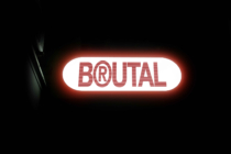 Glowing red neon sign reading BRUTAL on white rounded background
