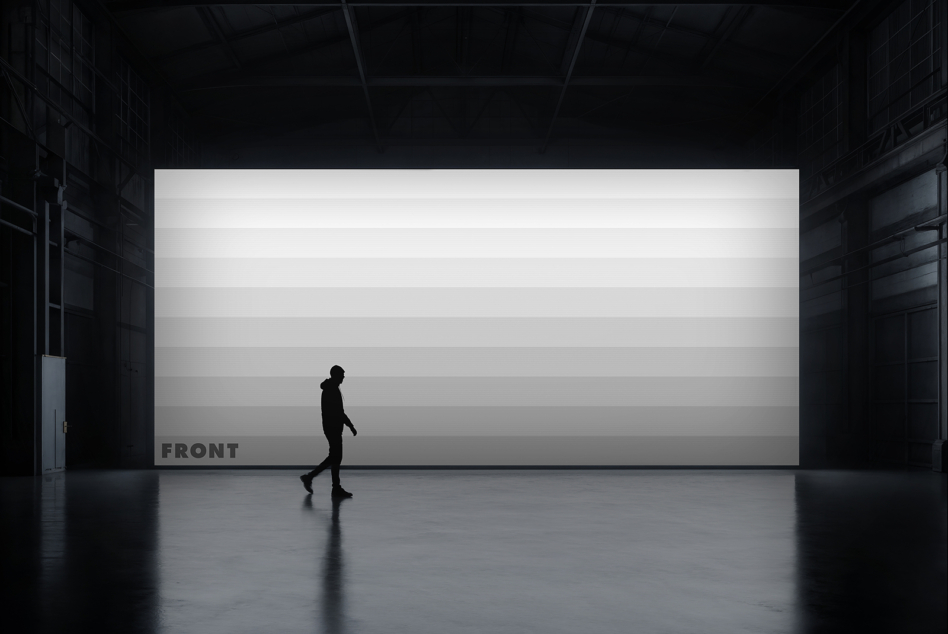Jogger moving past white billboard in concrete warehouse, dramatic overhead lighting