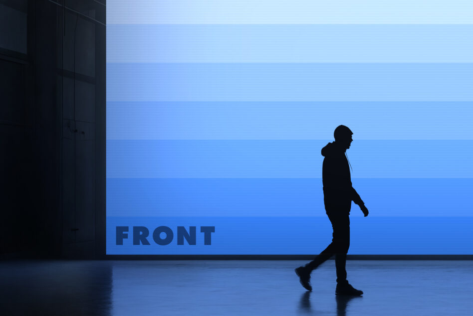 Runner passing blue gradient billboard in industrial space, silhouette shot