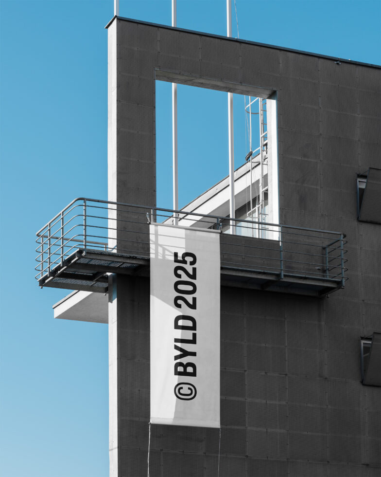 White vertical flag mockup with black text on modern building exterior