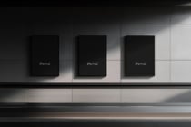 Three empty black frame mockups mounted on minimal gallery space