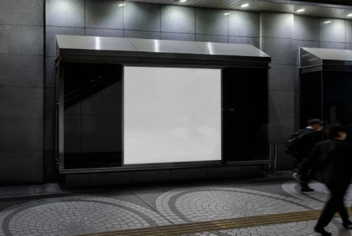 Storefront window mockup with blank poster display, sleek black frame, metal awning, urban street setting with blurred pedestrian passing by