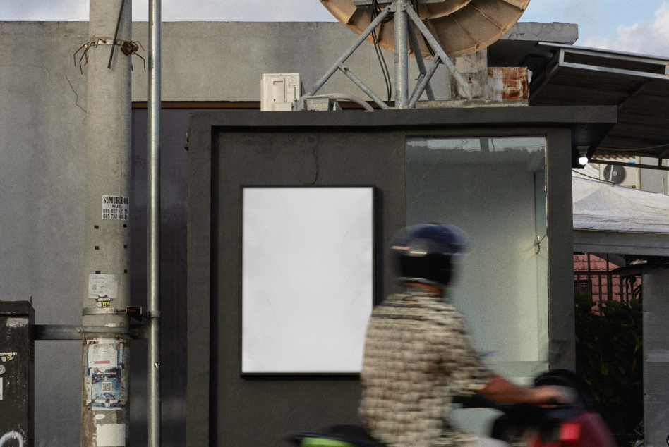 Blank poster on dark building facade with blurred people walking by
