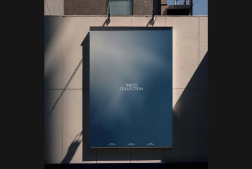 Overhead shot of blue poster hanging on minimal concrete wall with dramatic shadow play