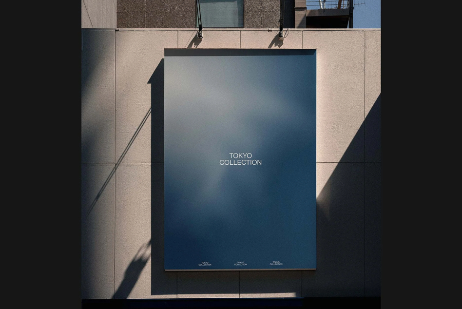 Overhead shot of blue poster hanging on minimal concrete wall with dramatic shadow play