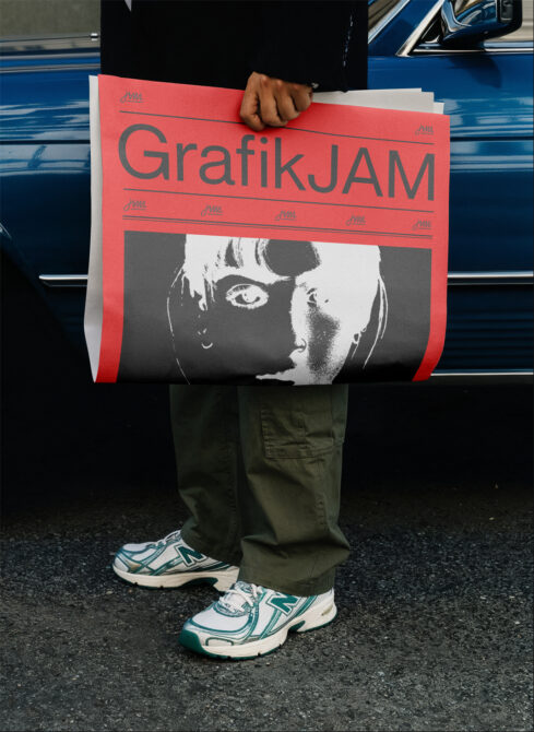 Red poster mockup with black portrait photo held up in front of vintage blue car