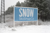 Roadside billboard with blue background showing SNOW text in white letters