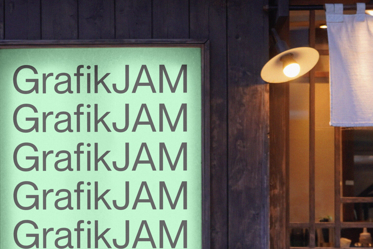 Lime green illuminated storefront sign repeating GrafikJAM text vertically