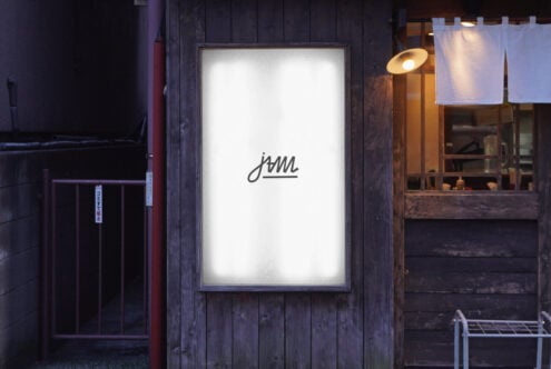 Bright white backlit storefront display with small JAM script logo centered