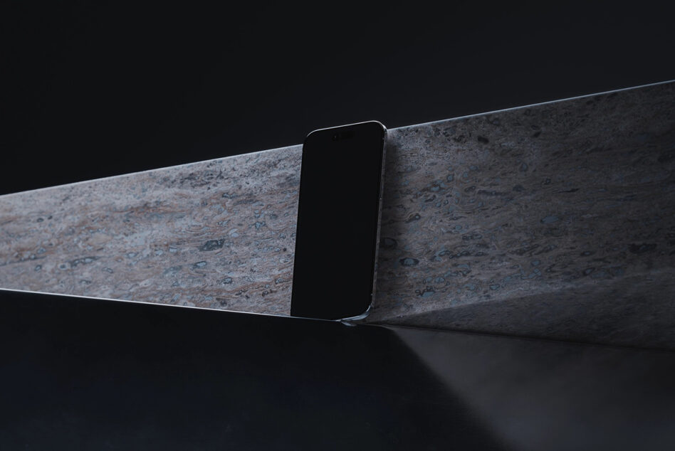 Minimalist phone resting on weathered concrete surface against black background
