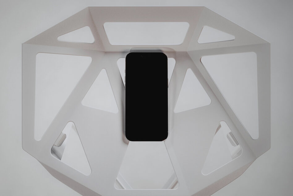 Overhead shot of phone with blank screen in white octagonal product showcase box