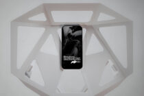 Phone displaying motion design inside white octagonal display box from above