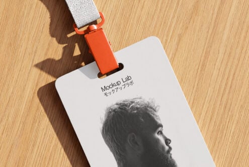 Bright orange lanyard attached to white badge with bearded guy's portrait