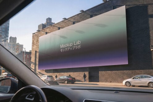 Car dashboard perspective of brick building with gradient digital billboard, Mockup Lab branding visible