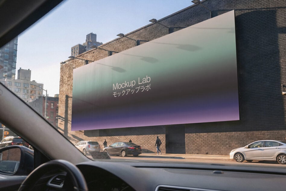 Car dashboard perspective of brick building with gradient digital billboard, Mockup Lab branding visible