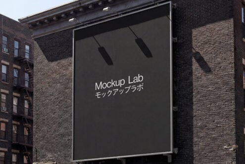 Large billboard on brick building displaying dark screen with hanging lights