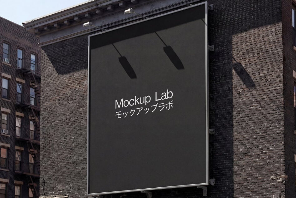Large billboard on brick building displaying dark screen with hanging lights